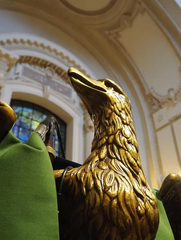 Gold eagle sculpture in front of a stained glass window