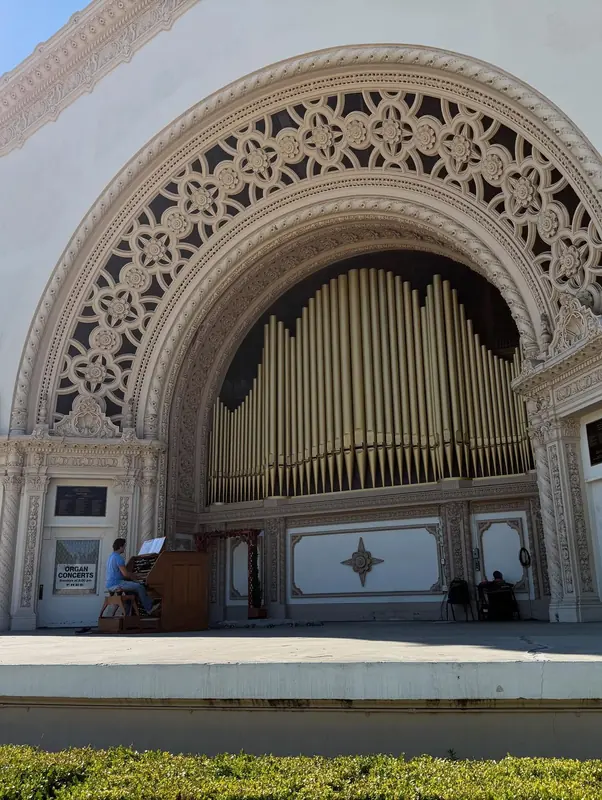 Ornate outdoor organ pavilion with a carved arch