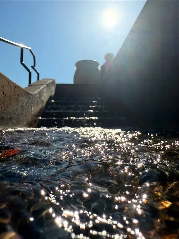 Sunlight sparkling on water running down stone steps