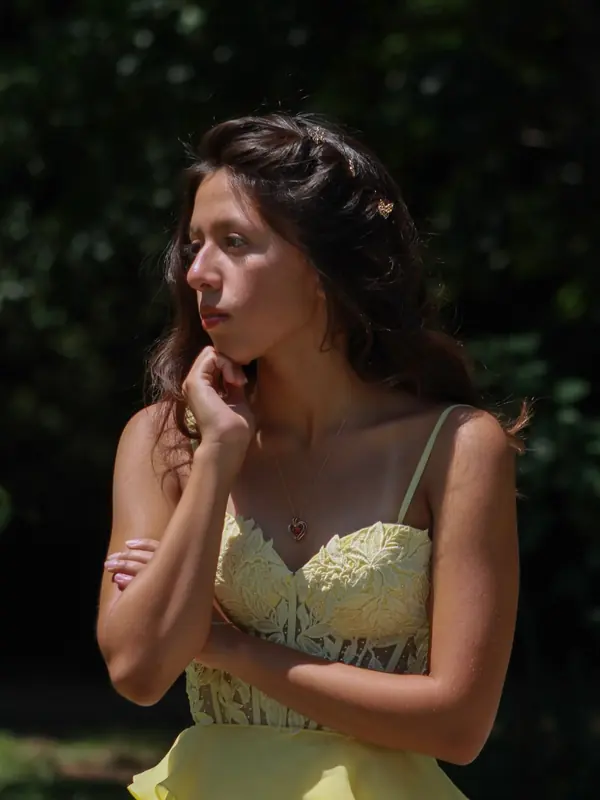 Quinceañera in soft shade resting her chin on her hand