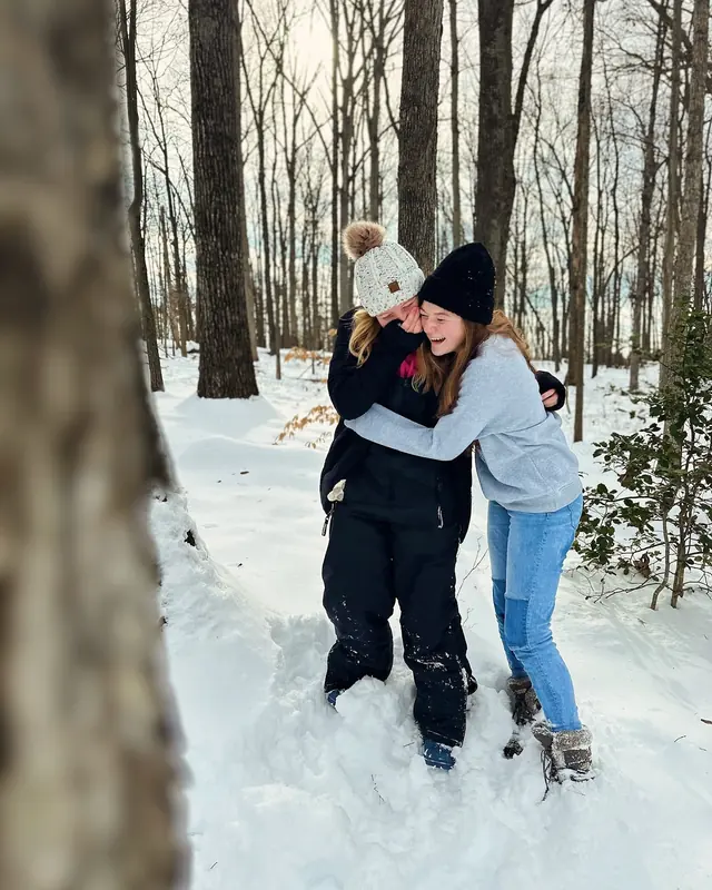 Two friends hugging in a snowy forest